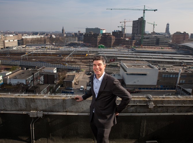 Jaap Balkenende met achter hem de sporen bij station Utrecht. Foto door Jorrit 't Hoen.